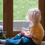 Niño mirando por ventana Moderna